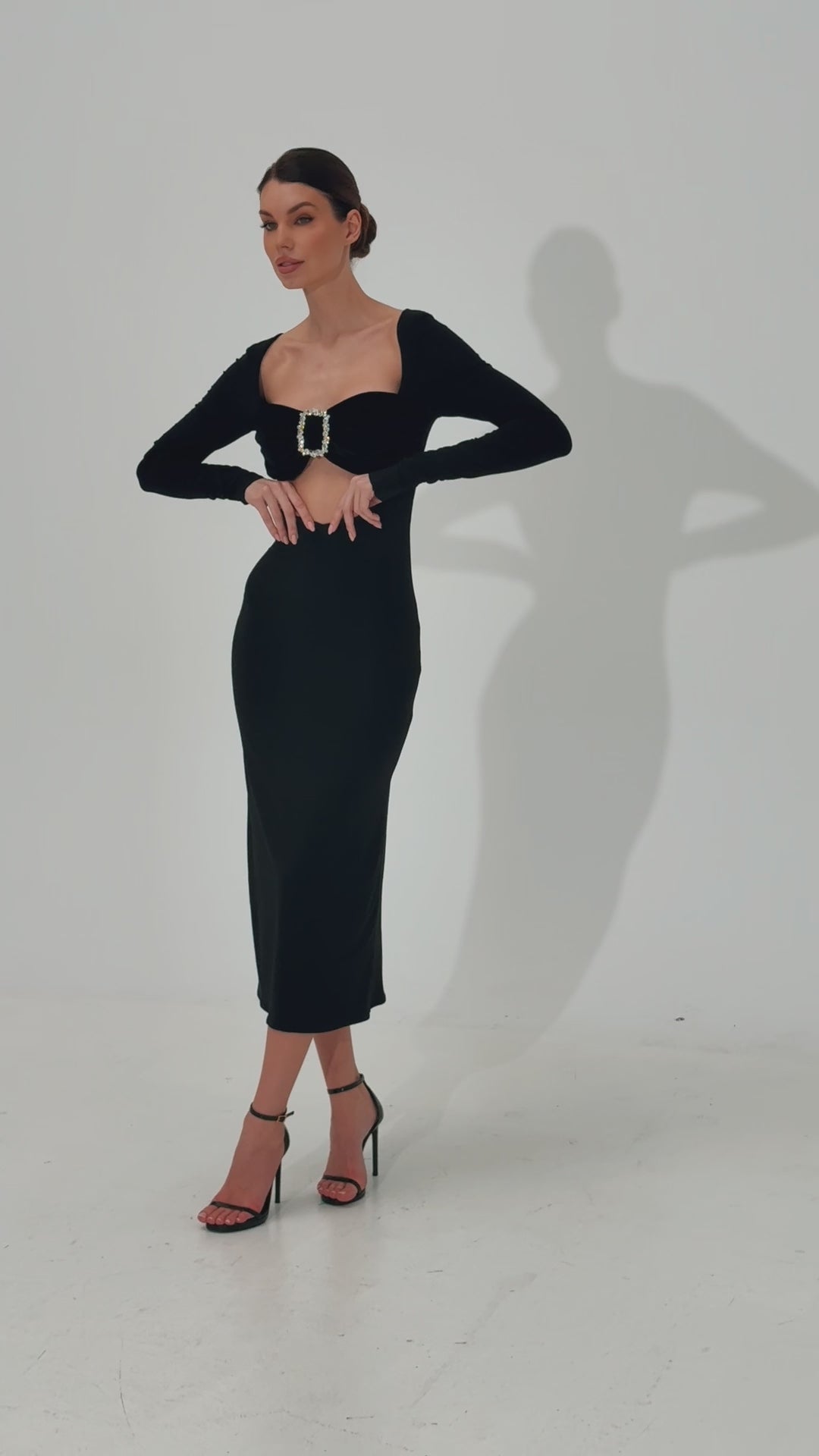 Video showcasing an elegant midi-length dress with a feminine silhouette, featuring a jersey skirt and a velvet bodice adorned with a crystal buckle.