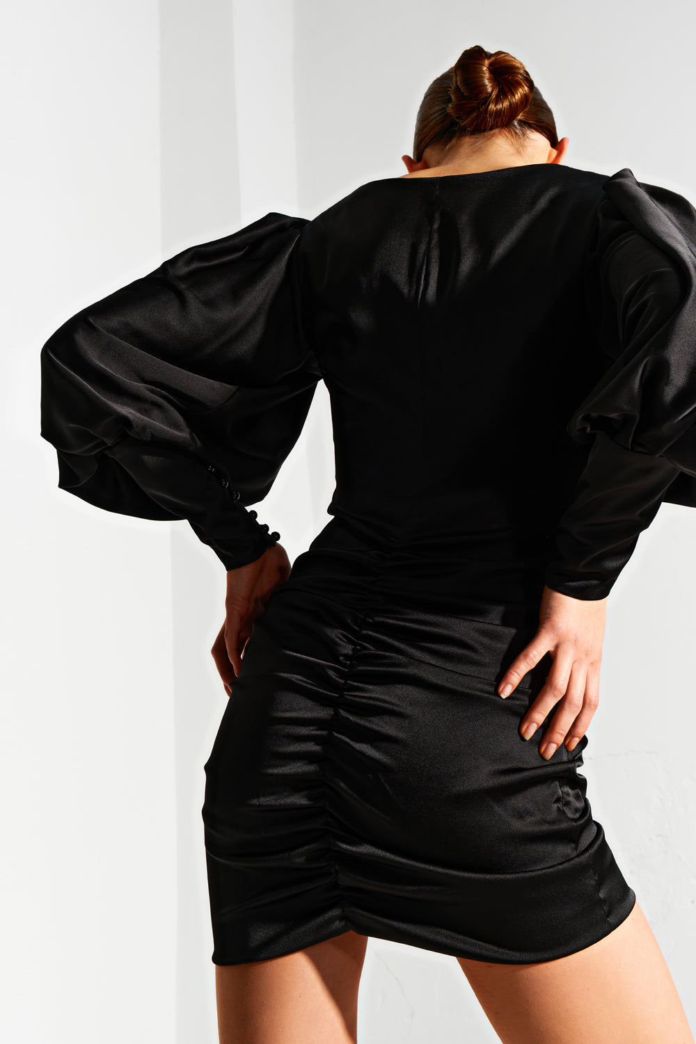 Black satin mini dress with sides and voluminous sleeve.