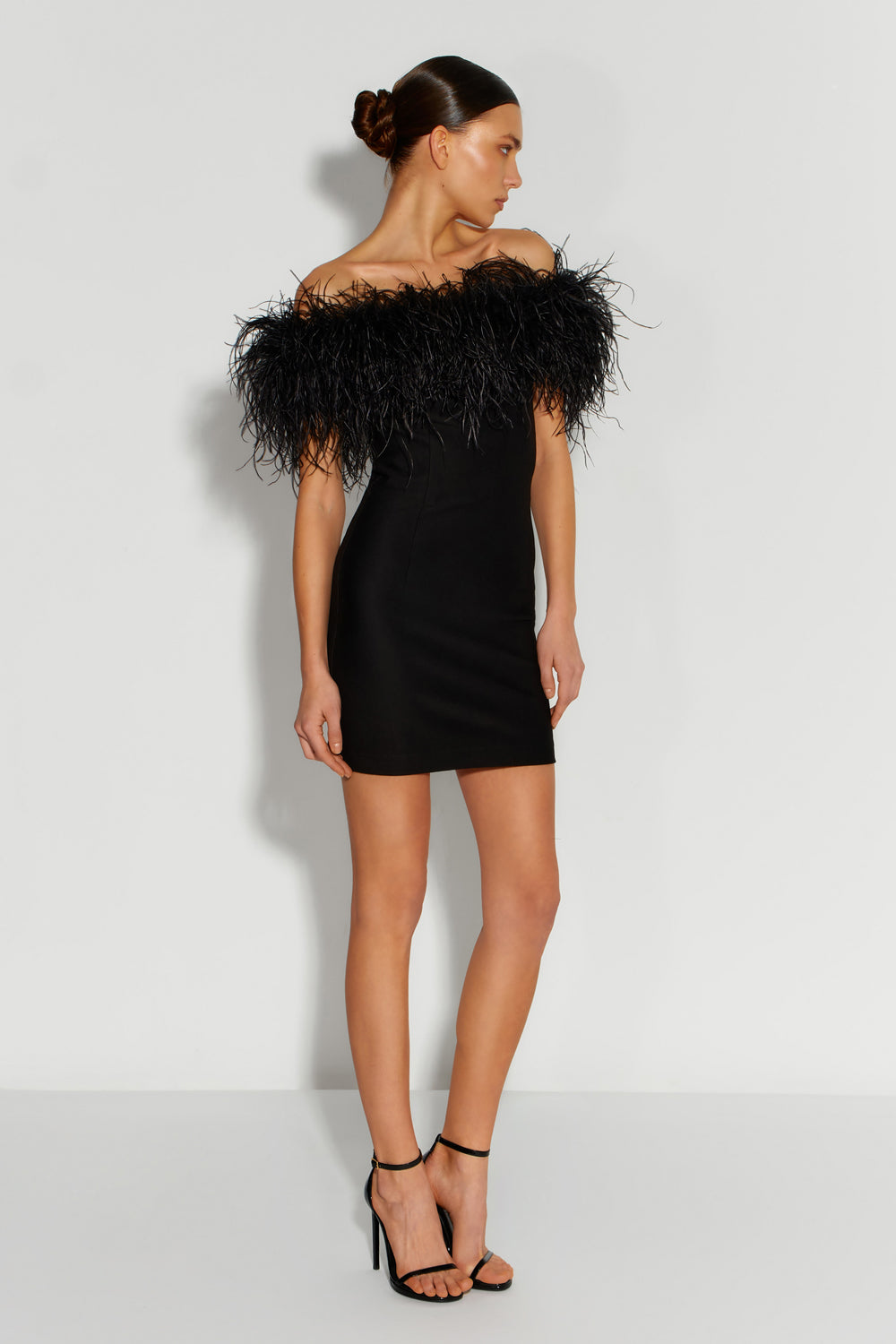 Black mini costume dress with feathers on the shoulders.
