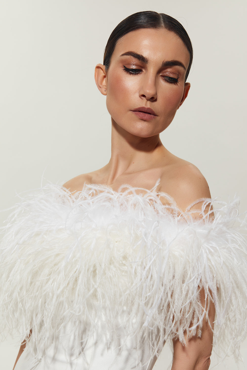 White mini costume dress with feathers on the shoulders.