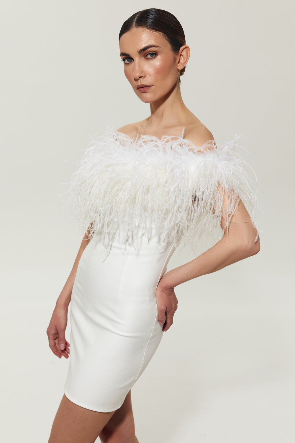 White mini costume dress with feathers on the shoulders.