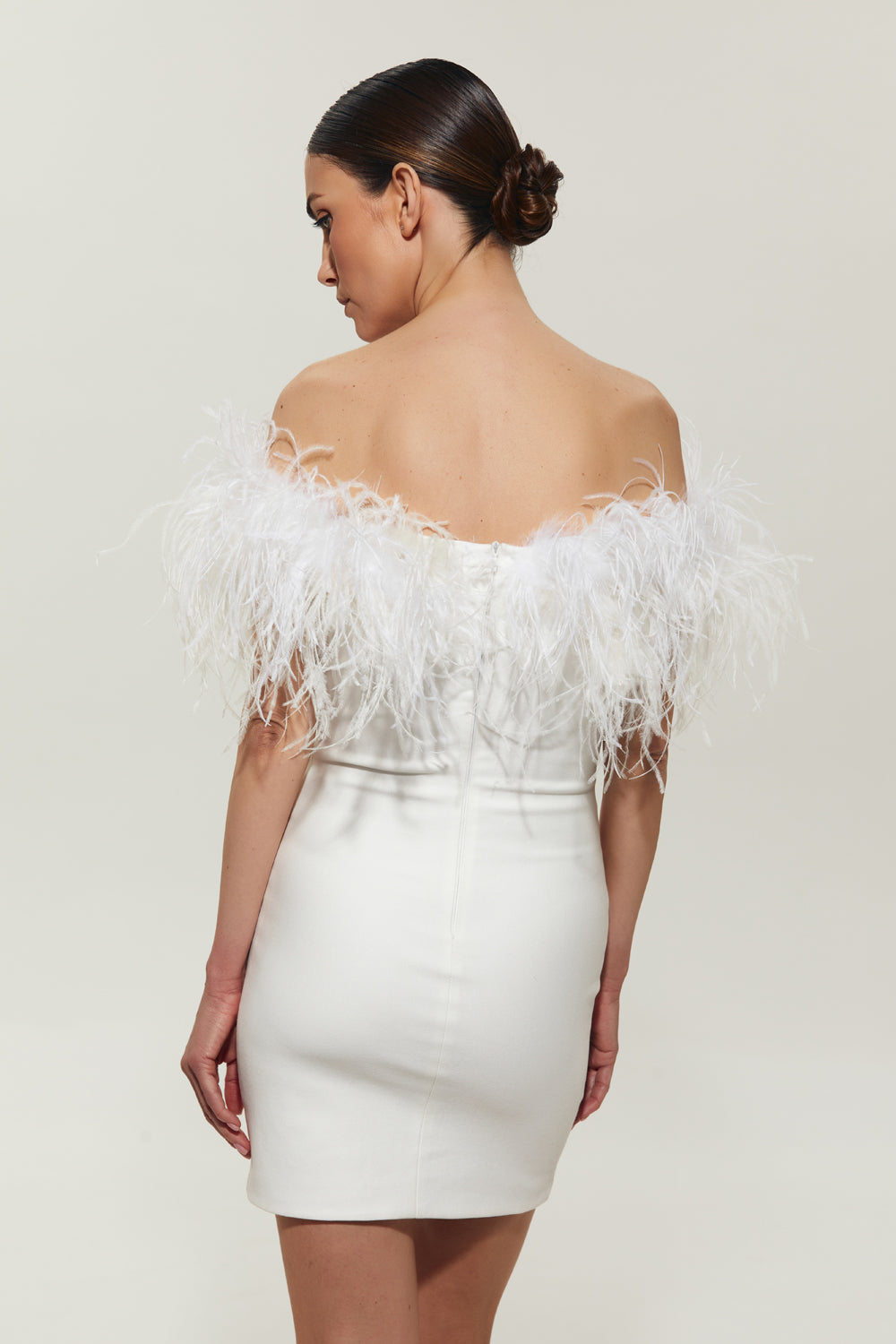 White mini costume dress with feathers on the shoulders.