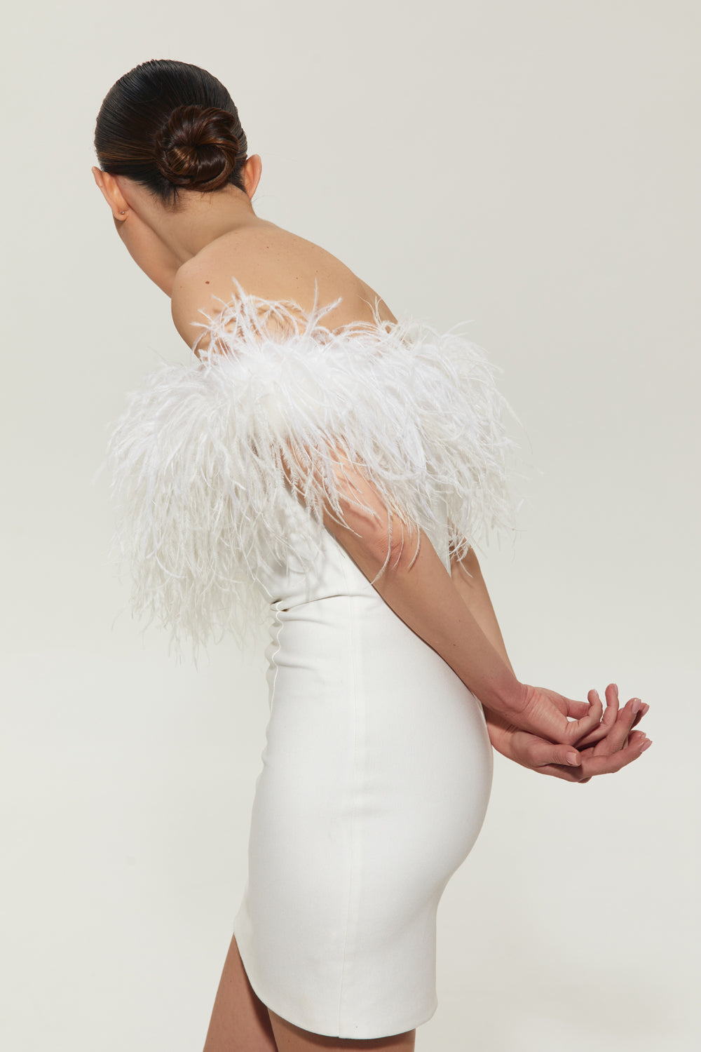White mini costume dress with feathers on the shoulders.