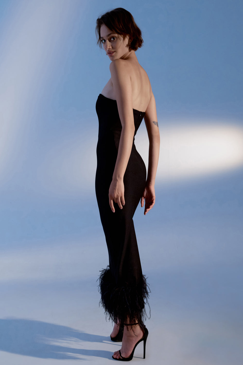 Black jersey midi dress with feathers on the bottom