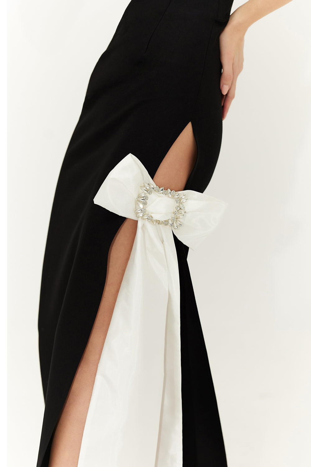 Black floor length bandage fabric dress with a bow at the slit.