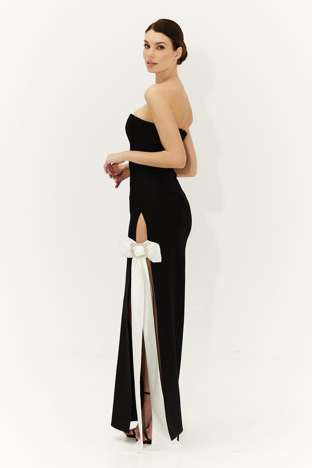 Black floor length bandage fabric dress with a bow at the slit.